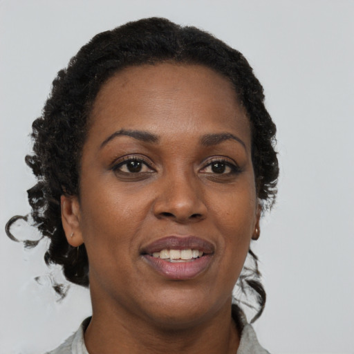 Joyful black adult female with short  brown hair and brown eyes