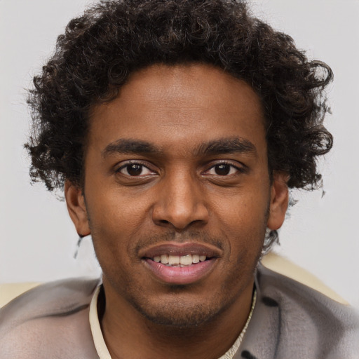 Joyful black young-adult male with short  brown hair and brown eyes