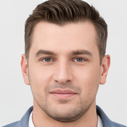 Joyful white young-adult male with short  brown hair and grey eyes