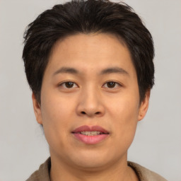 Joyful asian young-adult male with short  brown hair and brown eyes