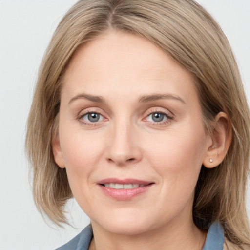 Joyful white adult female with medium  brown hair and grey eyes