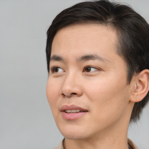 Joyful asian young-adult male with short  brown hair and brown eyes