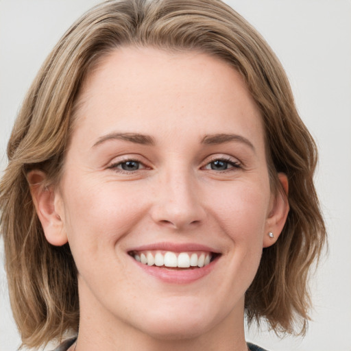 Joyful white young-adult female with medium  brown hair and blue eyes