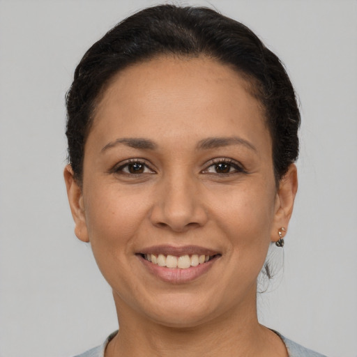 Joyful latino young-adult female with short  brown hair and brown eyes