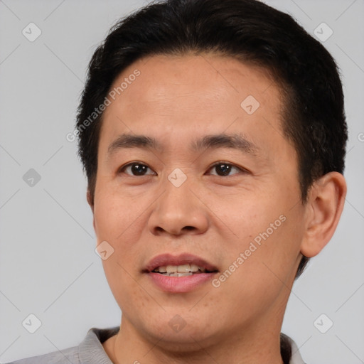 Joyful asian young-adult male with short  brown hair and brown eyes