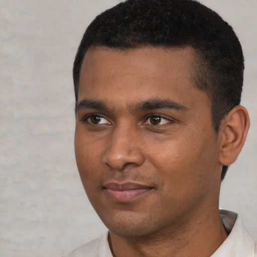 Joyful black young-adult male with short  black hair and brown eyes