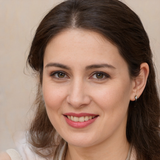 Joyful white young-adult female with long  brown hair and brown eyes