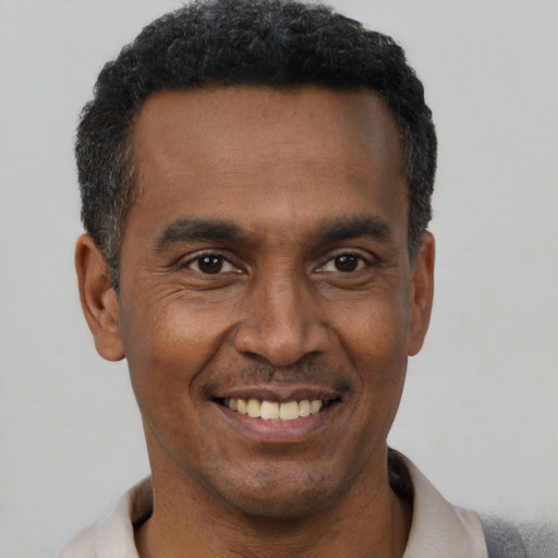 Joyful black young-adult male with short  black hair and brown eyes