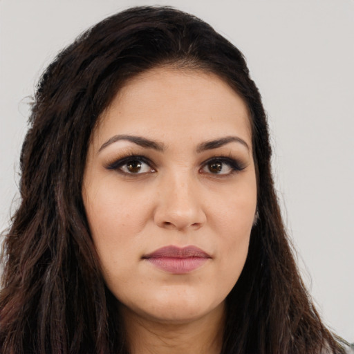 Joyful latino young-adult female with long  brown hair and brown eyes