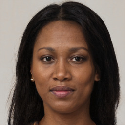 Joyful black adult female with long  brown hair and brown eyes