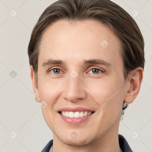 Joyful white young-adult male with short  brown hair and grey eyes