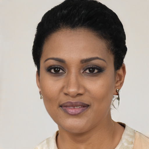 Joyful black young-adult female with short  black hair and brown eyes