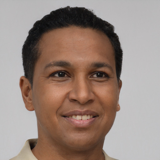 Joyful latino young-adult male with short  brown hair and brown eyes