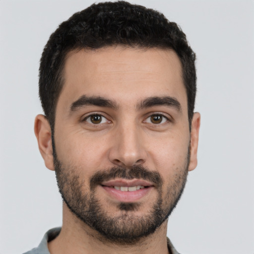 Joyful white young-adult male with short  black hair and brown eyes