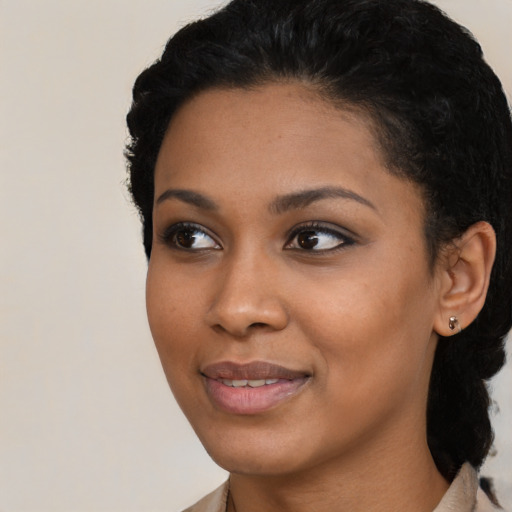 Joyful black young-adult female with short  black hair and brown eyes