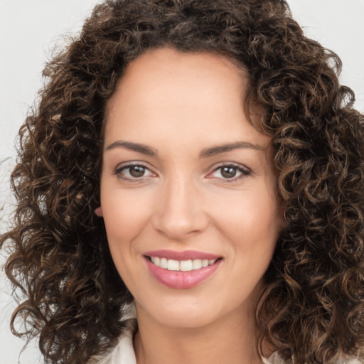 Joyful white young-adult female with long  brown hair and brown eyes