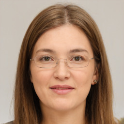 Joyful white young-adult female with long  brown hair and green eyes