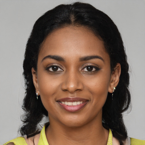 Joyful black young-adult female with medium  black hair and brown eyes