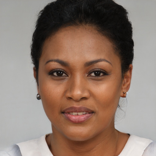Joyful black young-adult female with short  black hair and brown eyes