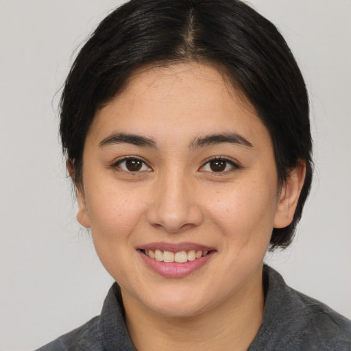 Joyful asian young-adult female with medium  brown hair and brown eyes