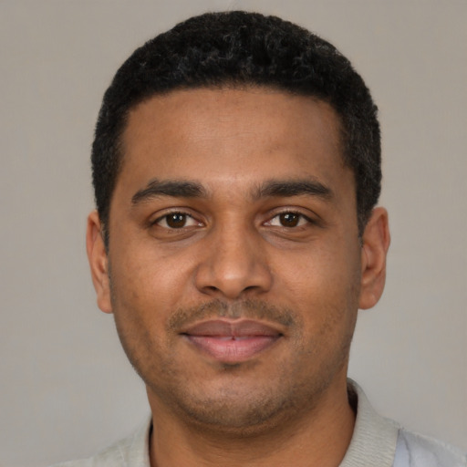Joyful black young-adult male with short  black hair and brown eyes