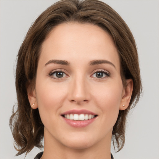 Joyful white young-adult female with medium  brown hair and green eyes