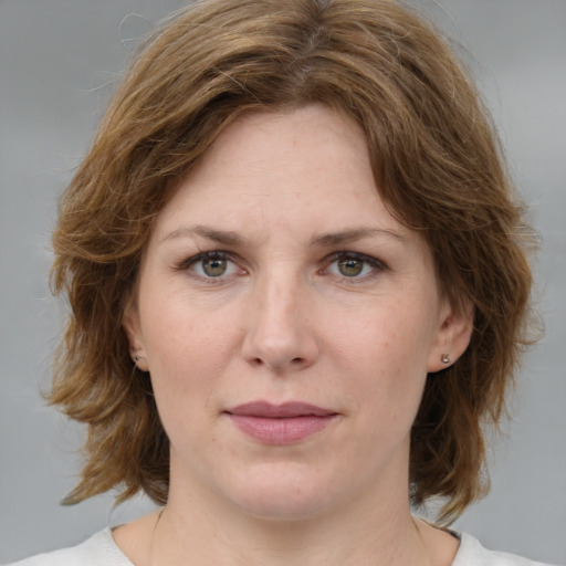 Joyful white young-adult female with medium  brown hair and green eyes