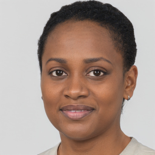 Joyful black young-adult female with short  black hair and brown eyes