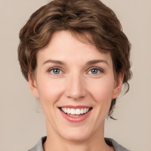 Joyful white young-adult female with short  brown hair and grey eyes