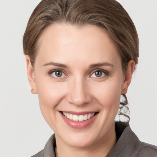 Joyful white young-adult female with short  brown hair and grey eyes