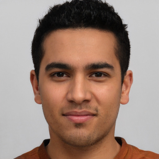 Joyful latino young-adult male with short  brown hair and brown eyes