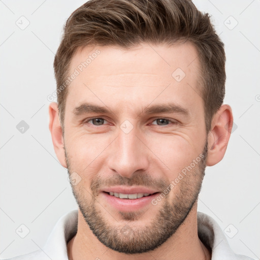 Joyful white young-adult male with short  brown hair and grey eyes