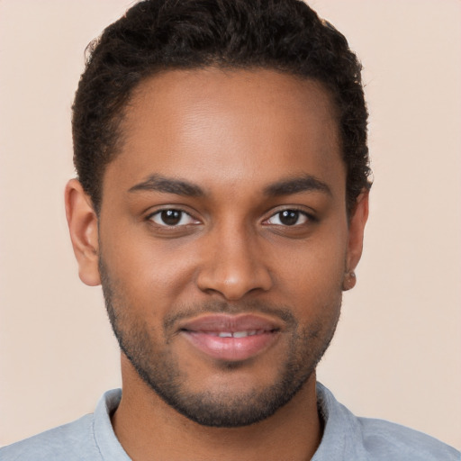 Joyful black young-adult male with short  brown hair and brown eyes