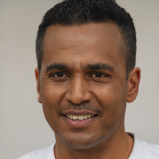 Joyful latino adult male with short  black hair and brown eyes