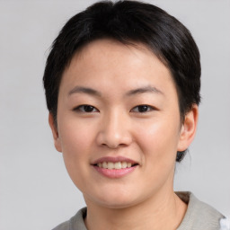 Joyful asian young-adult female with short  black hair and brown eyes