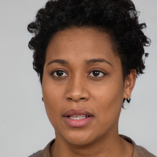 Joyful black young-adult female with short  brown hair and brown eyes
