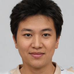 Joyful asian young-adult male with short  brown hair and brown eyes