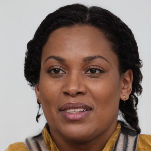 Joyful black adult female with medium  brown hair and brown eyes