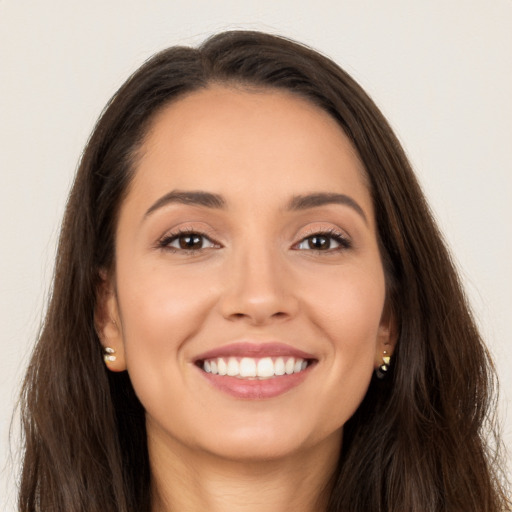 Joyful white young-adult female with long  brown hair and brown eyes