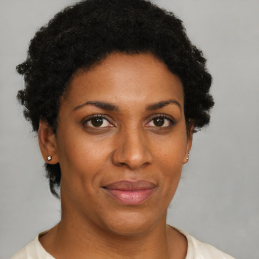 Joyful black young-adult female with short  brown hair and brown eyes