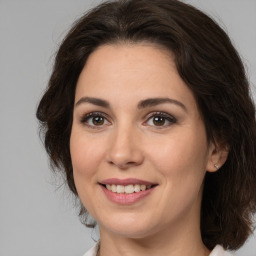 Joyful white adult female with medium  brown hair and brown eyes