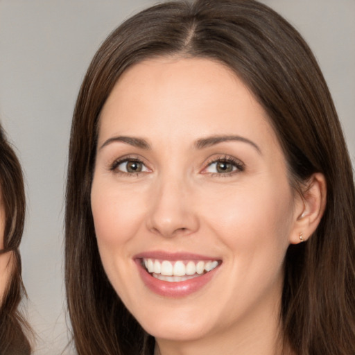 Joyful white young-adult female with long  brown hair and brown eyes