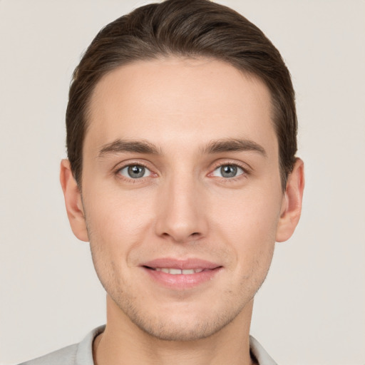 Joyful white young-adult male with short  brown hair and grey eyes