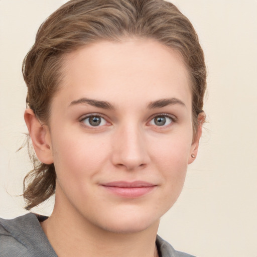 Joyful white young-adult female with medium  brown hair and grey eyes