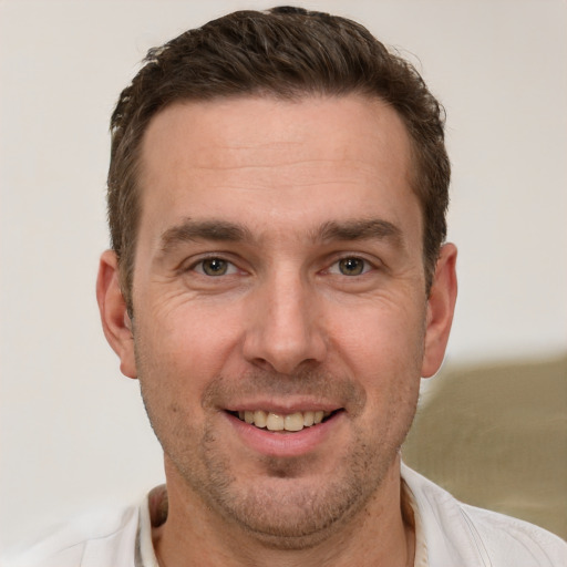 Joyful white adult male with short  brown hair and brown eyes