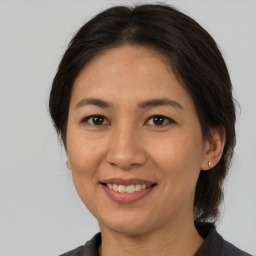 Joyful asian adult female with medium  brown hair and brown eyes