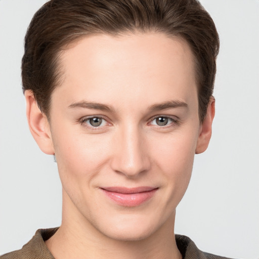 Joyful white young-adult female with short  brown hair and grey eyes