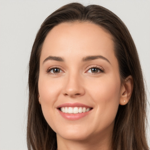 Joyful white young-adult female with long  brown hair and brown eyes