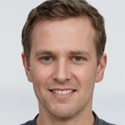 Joyful white young-adult male with short  brown hair and grey eyes