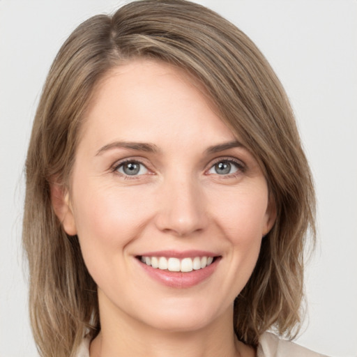 Joyful white young-adult female with medium  brown hair and green eyes